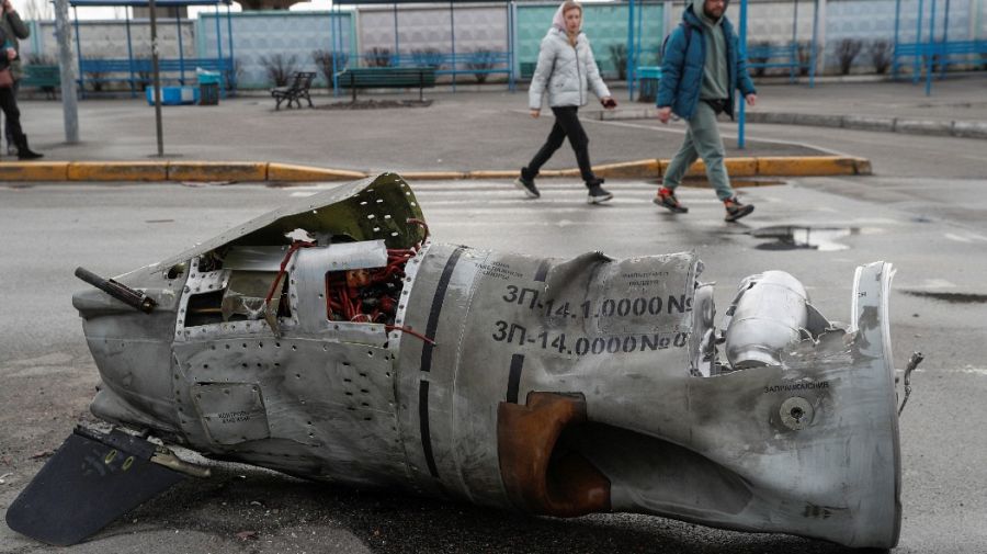 Unas personas cruzan ante los restos de un misil que impactó en una estación de autobuses en Kiev (4 de marzo).