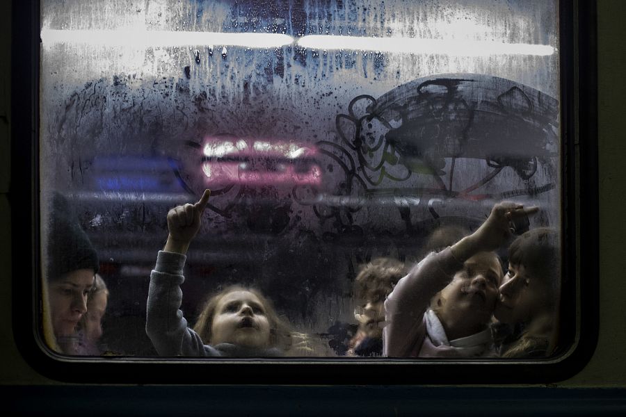 Una niña dibuja corazones en las ventanas del  tren  en la estación de Lviv en Ucrania que les llevará a Polonia