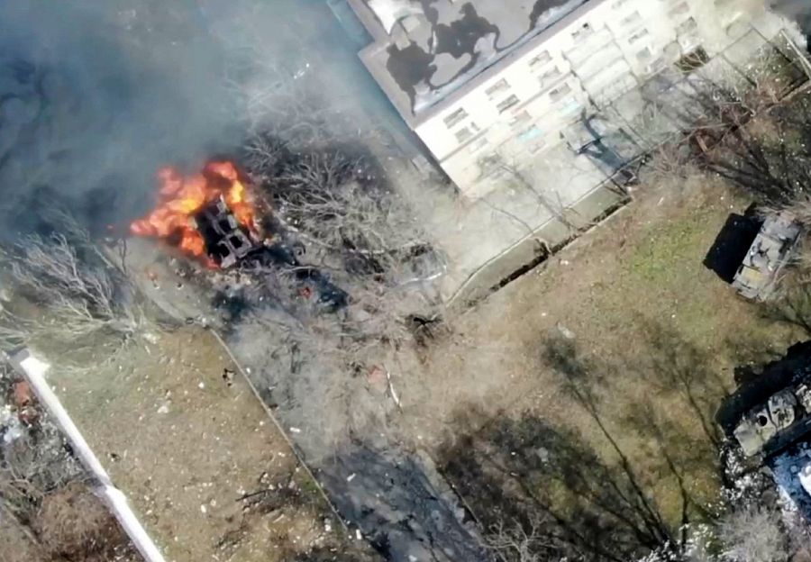 Mariúpol: Un vehículo militar frente a un edificio en llamas (13 marzo).