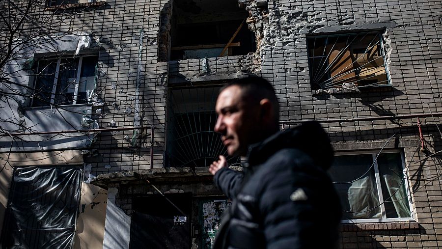 Un vecino de las afueras de Mykolaiv enseña como ha quedado su edificio tras un bombardeo del ejército ruso