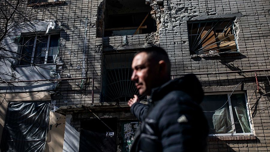 Un vecino de las afueras de Mykolaiv enseña como ha quedado su edificio tras un bombardeo del ejército ruso