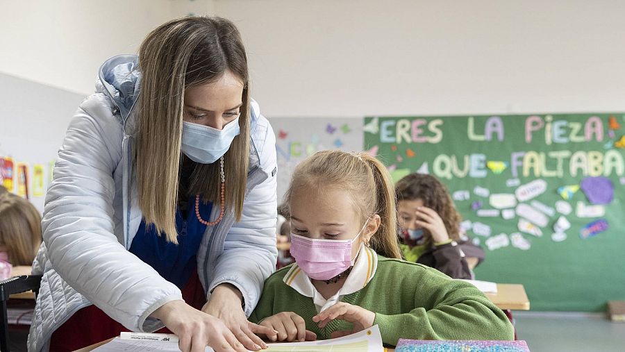 Una maestra de cuarto de primaria ayuda en clase a Margot de 10 años, una de las niñas escolarizadas, en el colegio Vistarreal de Molina de Segura