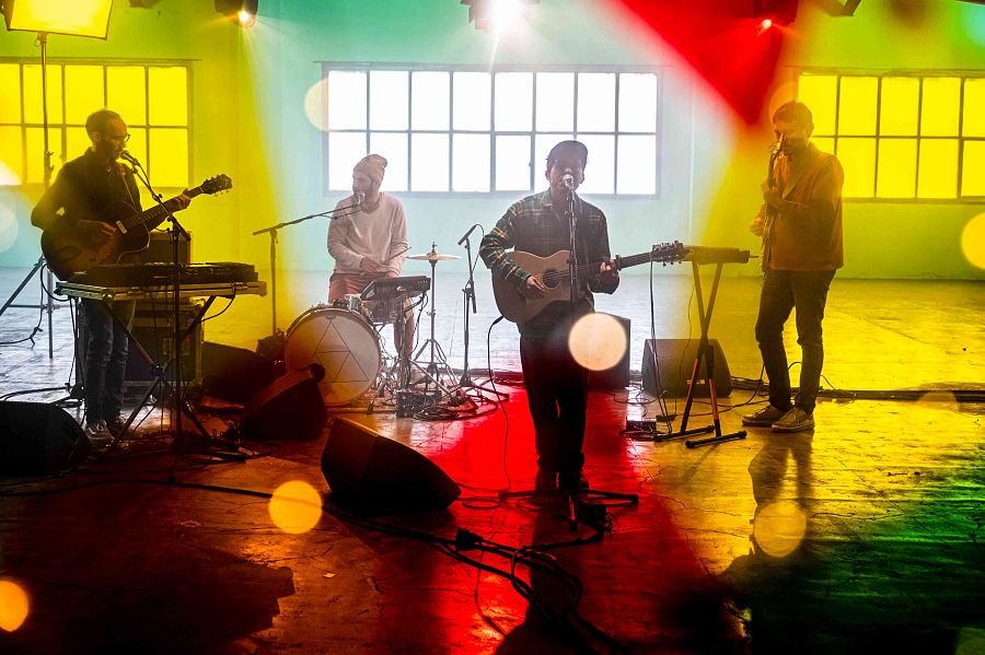 Foto de família del grup en un moment de l'actuacuó amb unes llums grogues i vermelles