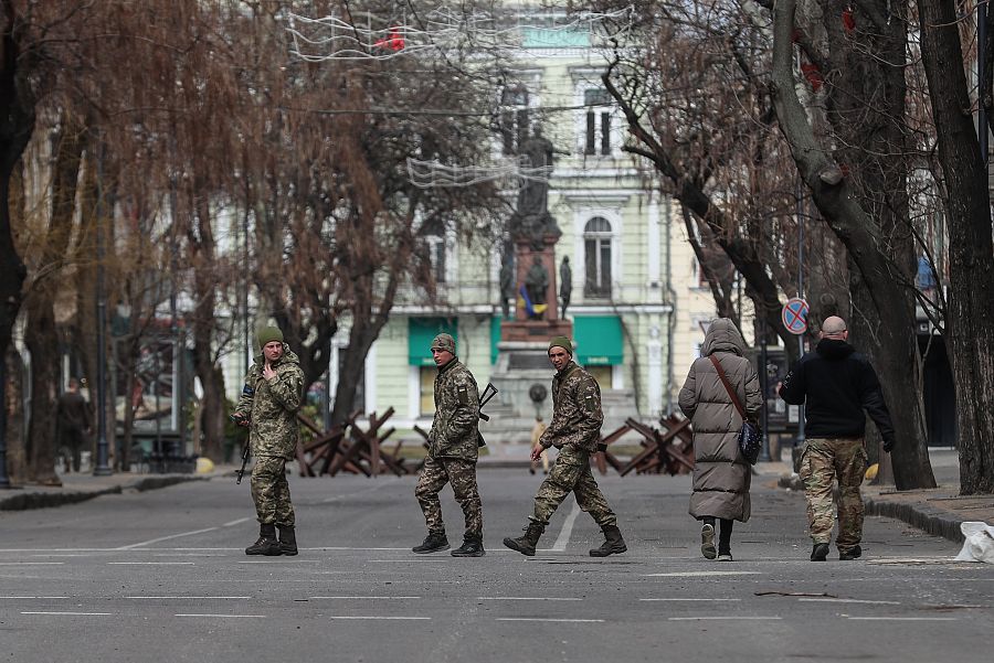 Soldados ucranianos caminan con sus armas junto a una barricada en Odesa.