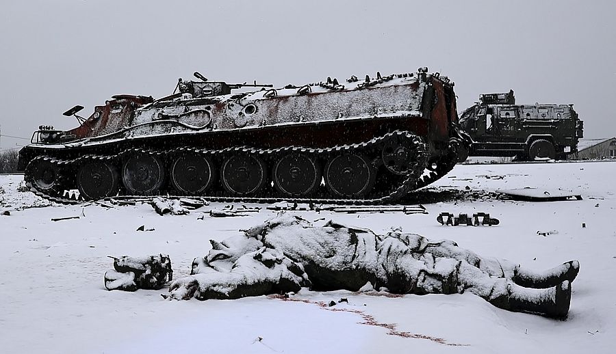 El cuerpo de un soldado yace sin vida junto a un vehículo de combate ruso. 