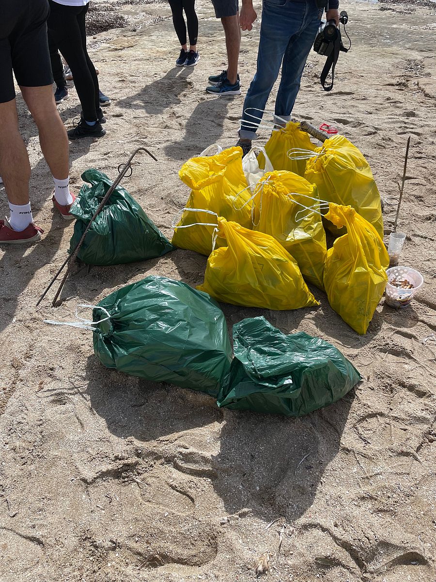 Bolsas de basura de dos colores llenas de residuos recogidos en una carrera de plogging.