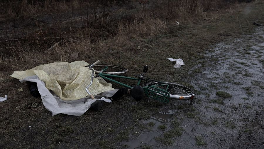 Una tela cubre a un civil muerto al lado de la bici en la que iba en Bucha