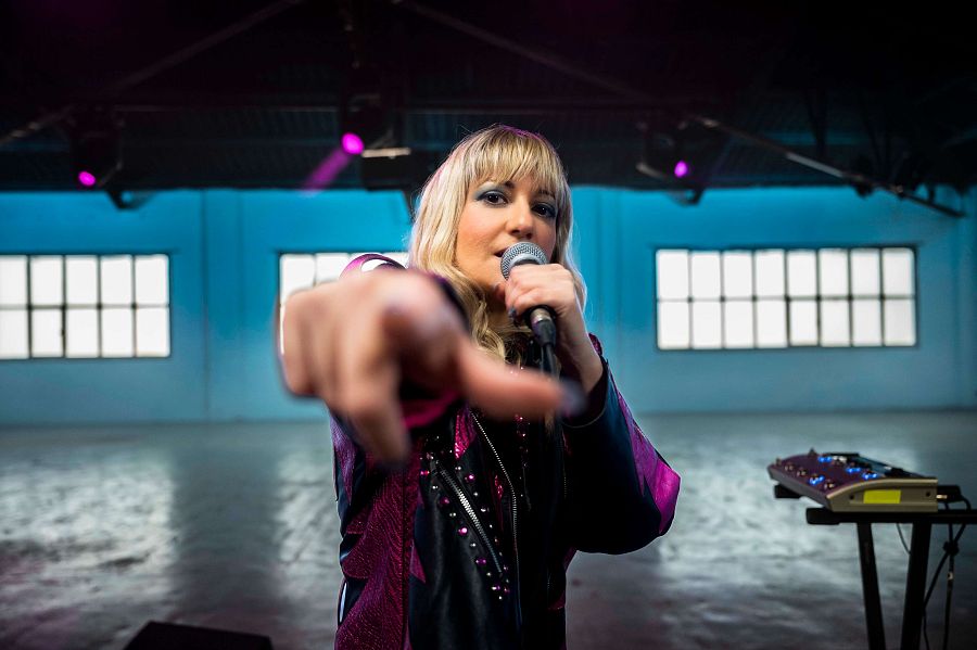 Un primer pla de Mar Ofrila amv el micròfon a la mà i assenyalant la càmera amb l'altre mà