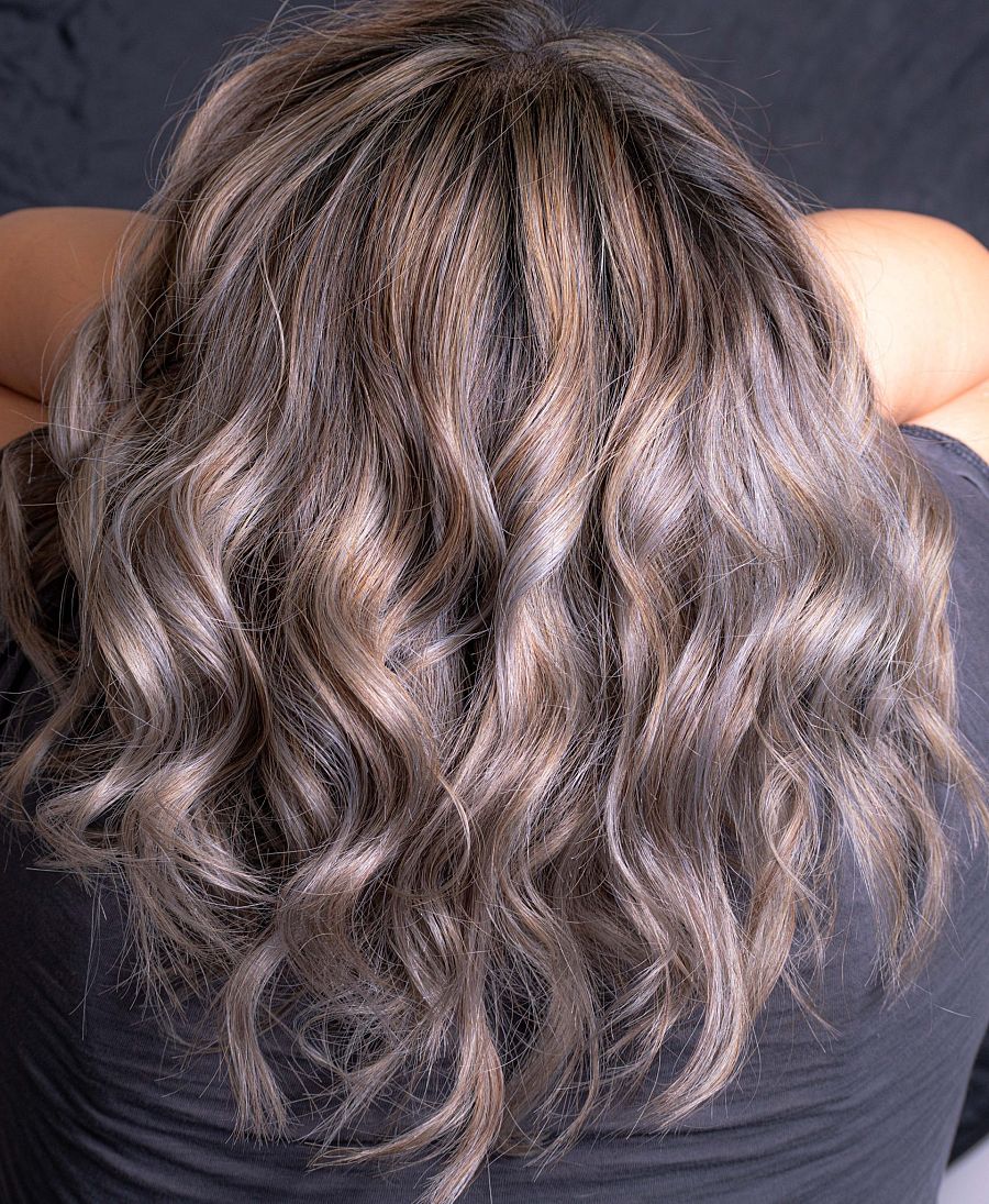 Para facilitar la transición muchas personas se tiñen mechones por todo el cabello para resaltar y matizar diferentes tonos de grises.