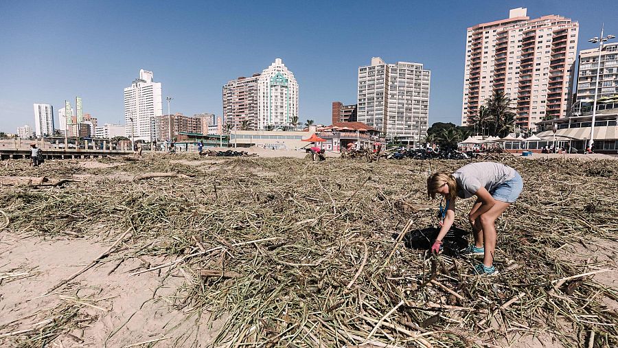 Voluntarios limpian una playa en Durban tras las inundaciones de esta semana.