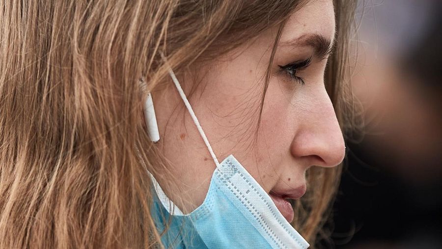 Cara de una joven con la mascarilla a medio quitar