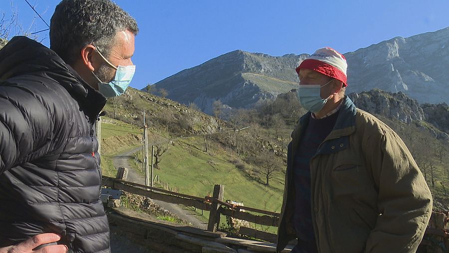 Un pastor de cabras asturiano conversa con el reportero de Comando Actualidad con los Picos de Europa de fondo.