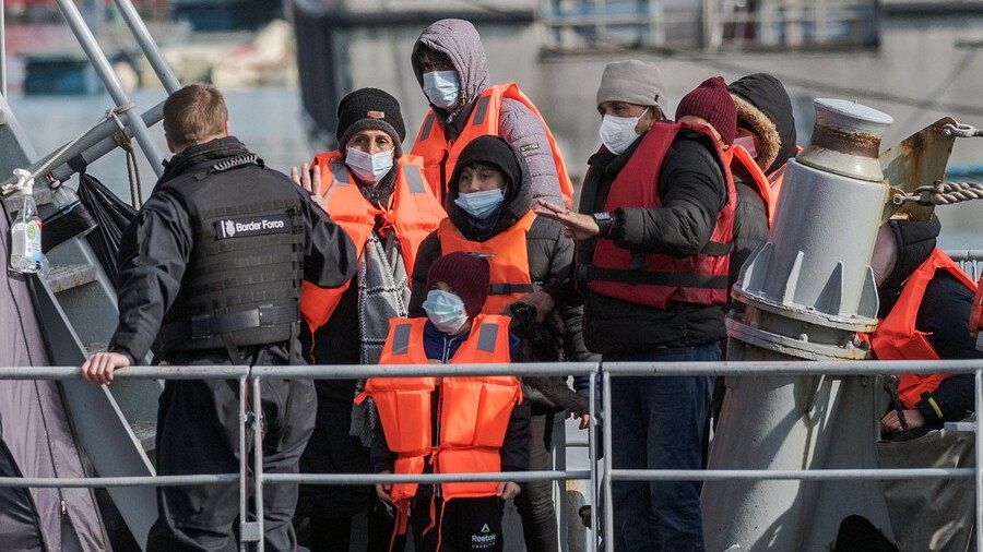Inmigrantes escoltados por oficiales de la Fuerza Fronteriza y miembros del ejército después de cruzar el Canal de la Mancha en Dover, Reino Unido