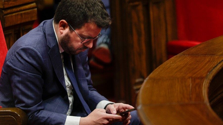 El president de la Generalitat, Pere Aragonès, mira el seu mòbil al Parlament