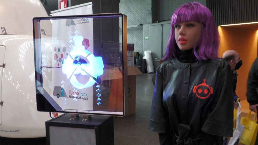 Un robot con apariencia de joven y pelo morado.