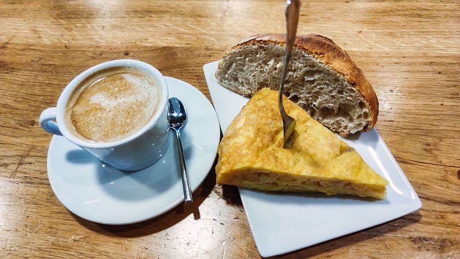 Tapa de tortilla acompañado de un café
