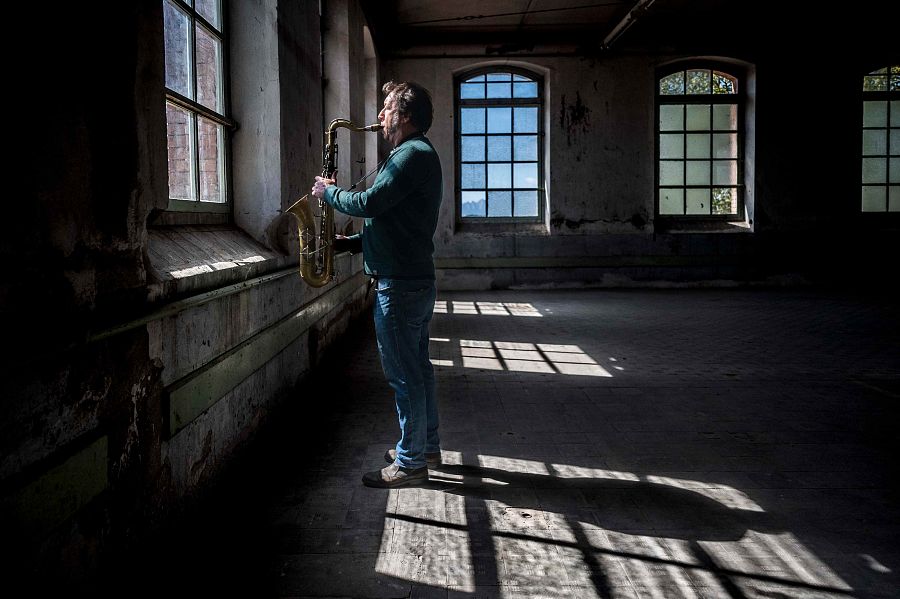 Gorka Benítez tocan el saxòfon davant d¡una finestra
