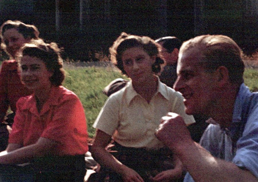 Isabel, de rojo, sentada en Balmoral con otros jóvenes: en primer plano su novio, Felipe de Grecia