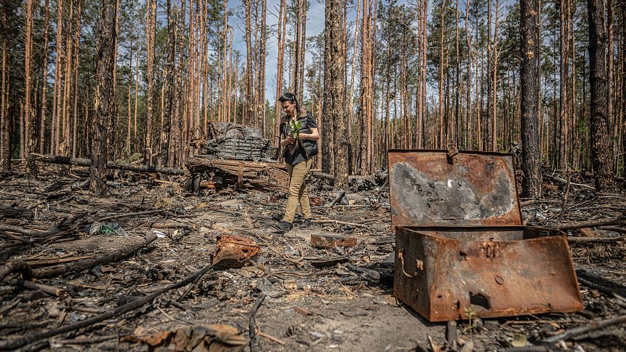 Oksana sujeta un ramo de flores mientras observa los restos del bombardeo