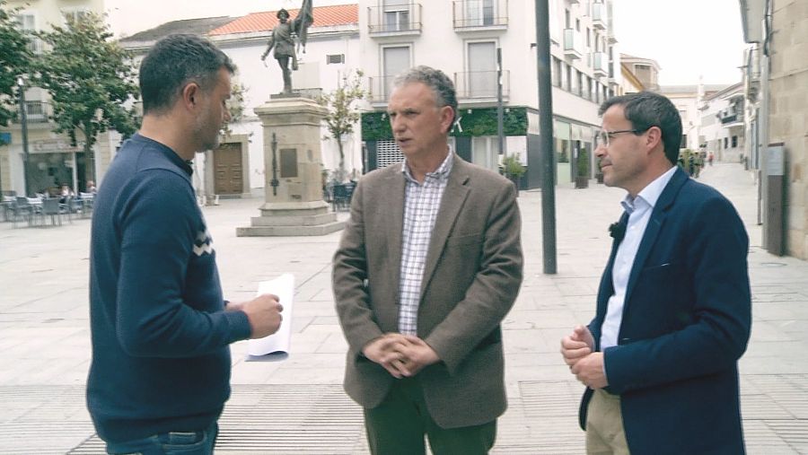 Uno de los reporteros de Comando actualidad conversando con dos hombres en una plaza de Don Benito