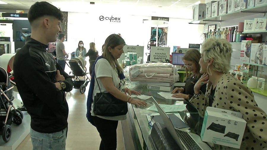 Una familia compra accesorios para bebé en una tienda especializada.