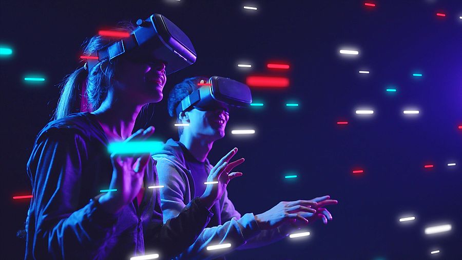 Un hombre y una mujer con gafas de realidad virtual rodeados de ráfagas que simulan el mundo virtual
