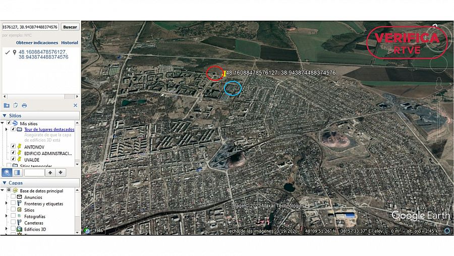 Captura de Google Earth Pro con la torre de ladrillo que observamos en los vídeos rodeada por un círculo rojo y el edificio dañado con un círculo azul con el sello: VerificaRTVE