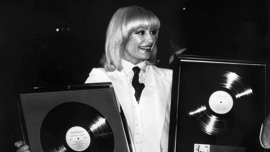 Raffaella Carrà sosteniendo los dos discos de oro que ganó en 1982 en España