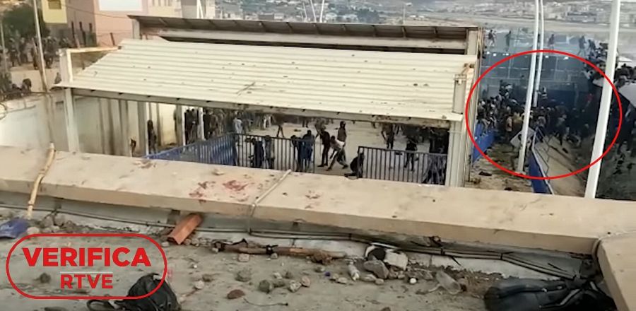 Imagen del vídeo del min 1:41 donde se observa el foso, lugar en el que parecen haberse amontonado los inmigrantes con el sello de VerificaRTVE en rojo.