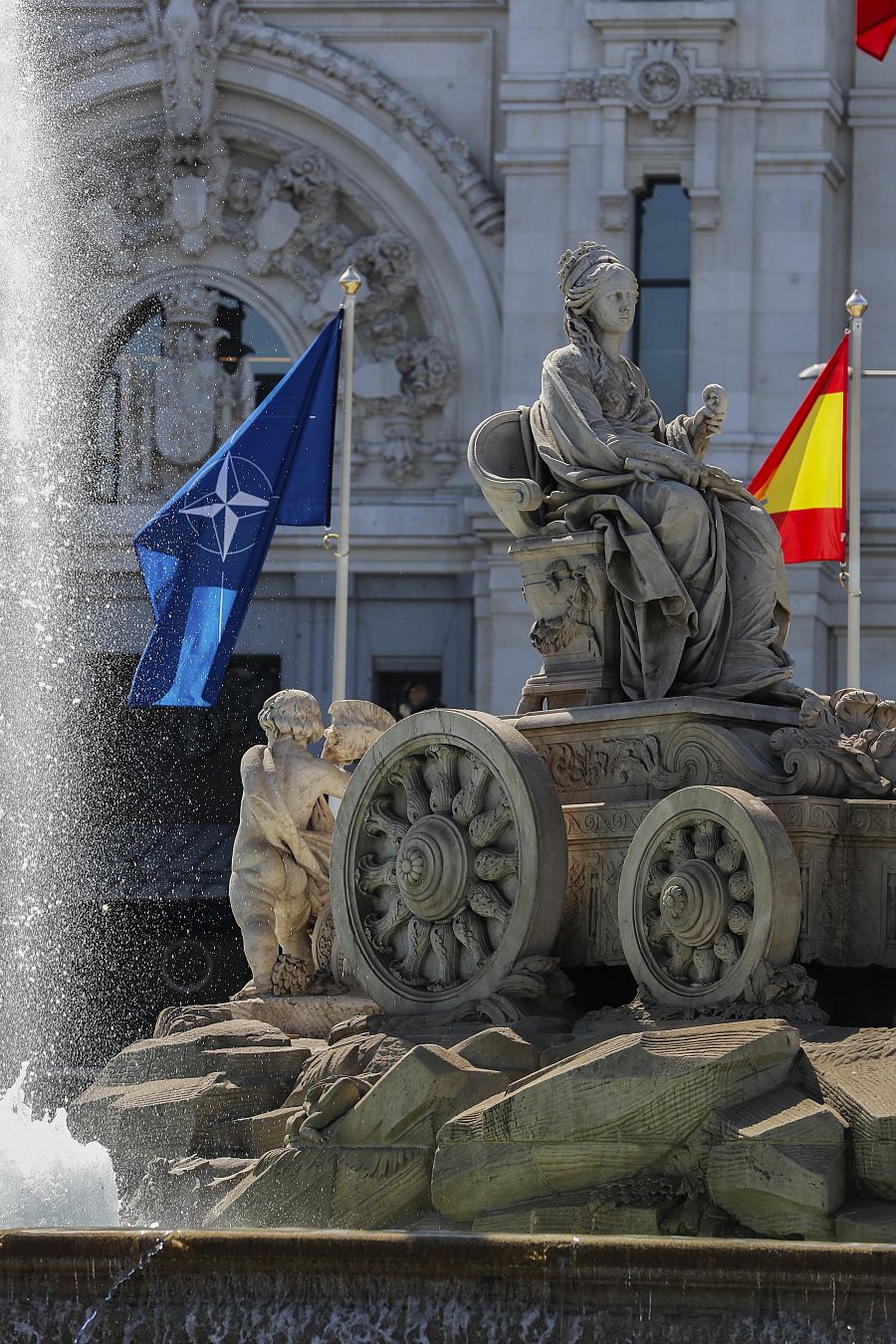 Vista de la fuente de La Cibeles en Madrid con las banderas de España y de la OTAN