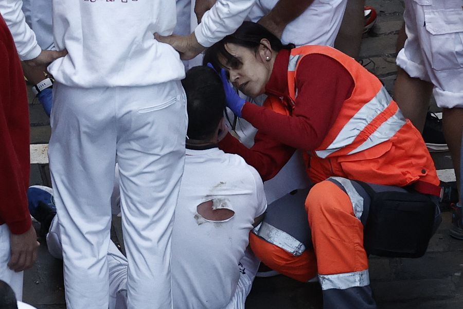 Los servicios de Cruz Roja atienden a un herido por magulladuras tras el segundo encierro.