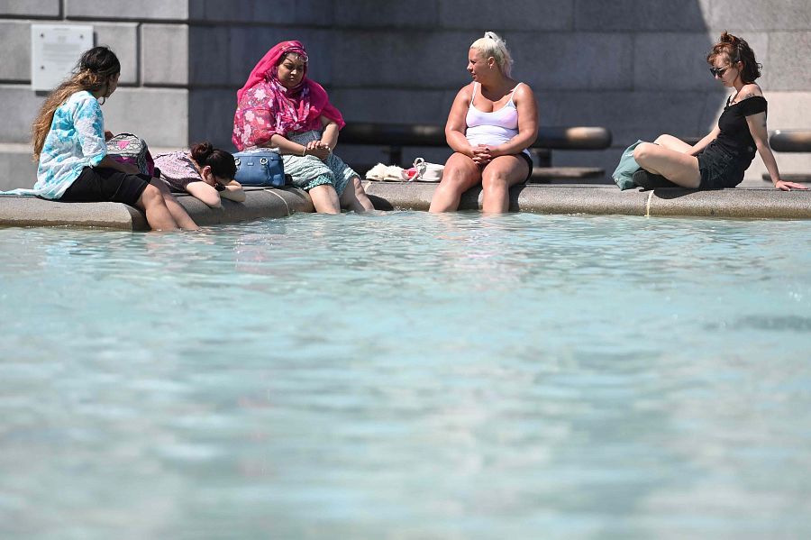 La gente se refresca en una fuente de Trafalgar Square en Londres