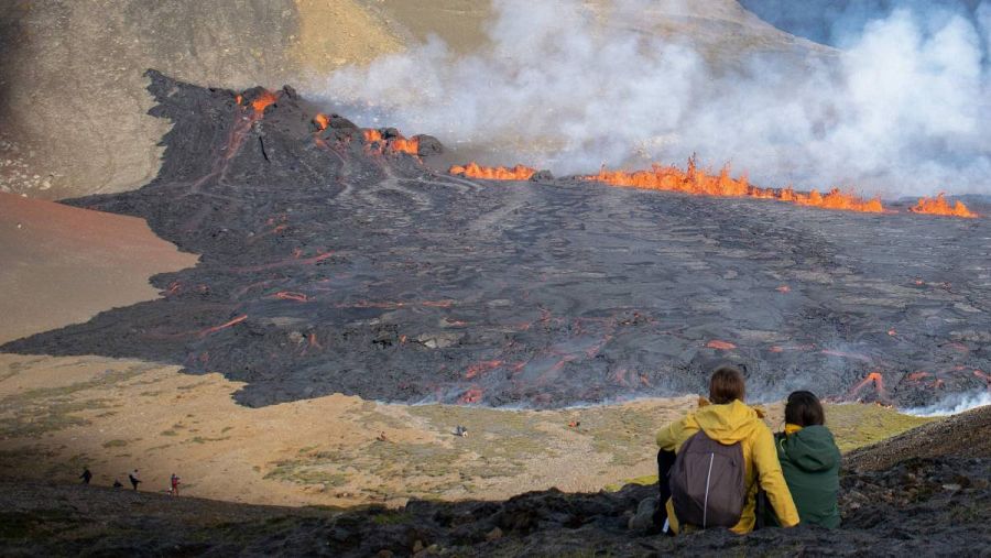 La gente mira la lava que fluye en la escena del volcán en erupción recientemente en Grindavik, Islandia.