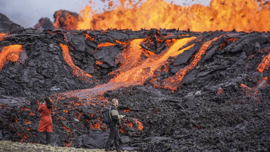 La gente mira la lava que fluye en el volcán Fagradalsfjall en Islandia.