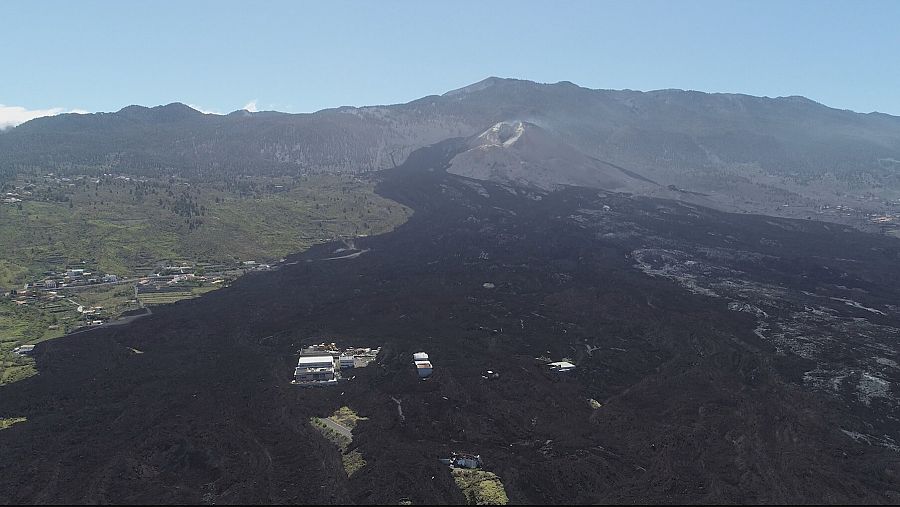 Imagen del recorrido de la colada bajo la que hay enterradas centenares de casas, al fondo el volcán