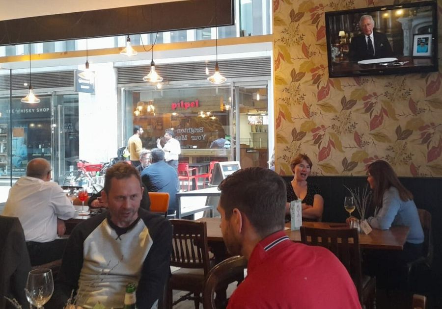 Británicos toman algo en un pub en Londres mientras Carlos III ofrece su primer discurso como rey