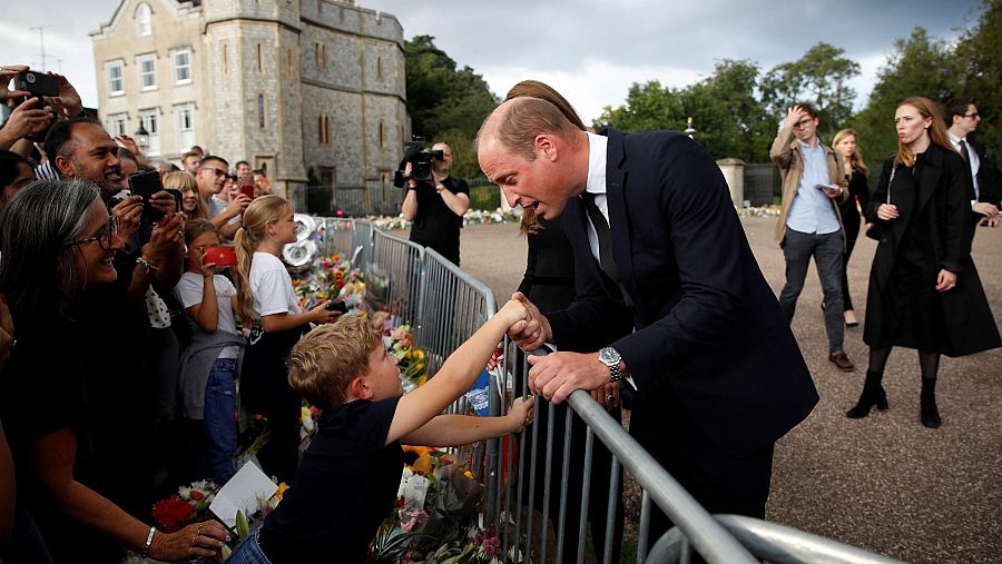 Guillermo, príncipe de Gales, saluda a la multitud en los exteriores del palacio de Buckingham.