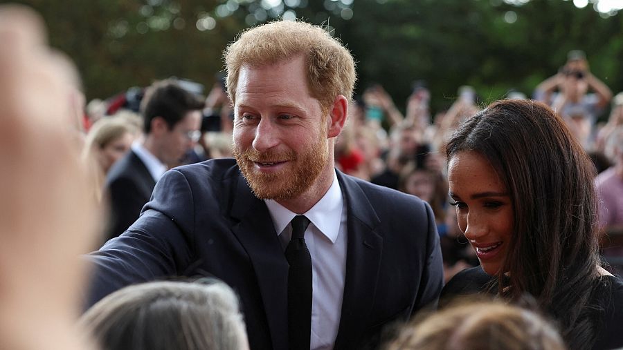 El príncipe Enrique y su mujer, Meghan, duquesa de Sussex, saludan a la multitud a las puertas del castillo de Windsor.