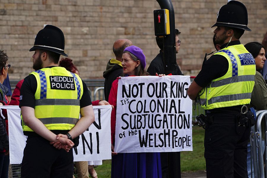 Un grupo de personas protesta antes de la proclamación real en el castillo de Cardiff, Gales