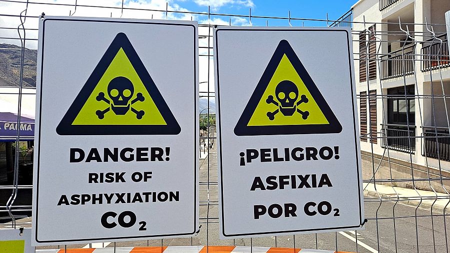 Cartel con dos calaveras negras sobre fondo amarillo, alertando sobre el peligro de gases tóxicos en Puerto Naos