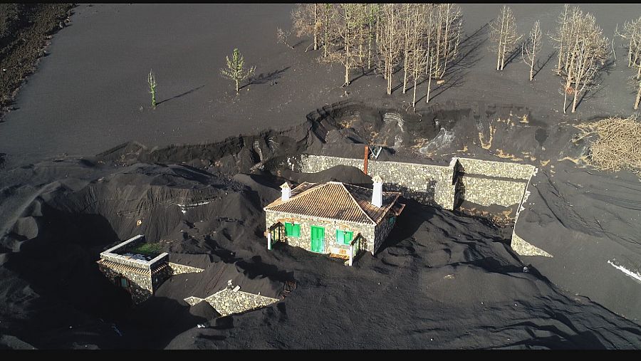 Imagen de una casa semienterrada por la ceniza que llega hasta las ventanas