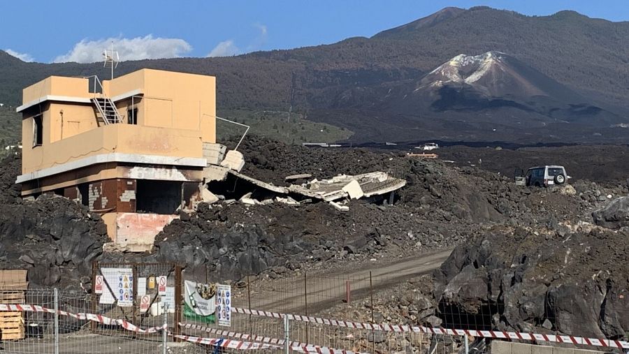 Imagen de una casa destruida con el volcán fondo en la carretera que une La Laguna con Las Norias