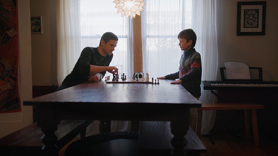 Padre juega al ajedrez con su hijo