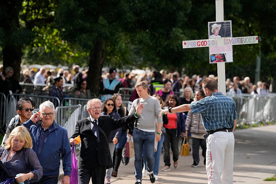 La gente hace cola al comienzo de la línea de más de seis kilómetros de largo cerca del Puente de la Torre para presentar sus respetos a la difunta reina Isabel II