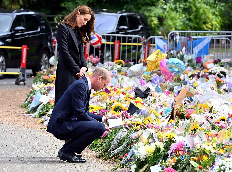Guillermo y Catalina, príncipes de Gales, observan las flores dejadas en homenaje a la difunta reina Isabel II en Norwich Gates en Sandringham