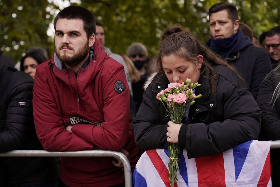 Una mujer lleva flores al centro de Londres durante el funeral de Isabel II