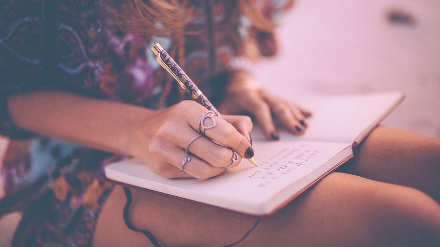 Una chica está escribiendo en su cuaderno