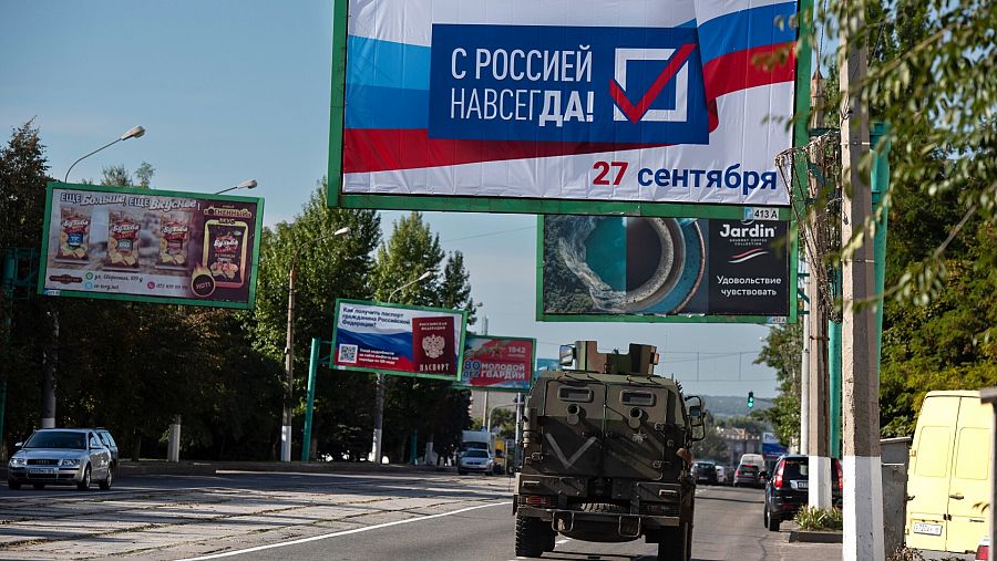 Imagen de archivo de un vehículo militar ruso en Lugansk (Ucrania) bajo un cartel propagandístico del referéndum de anexión a Rusia, con el lema 