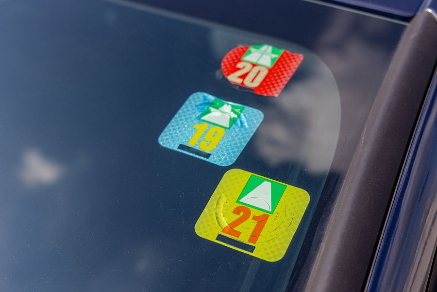 Viñeta de tres pegatinas de impuestos de circulación suizos en el parabrisas del coche