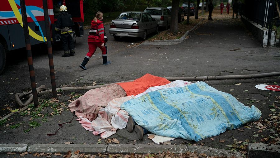 Tres cuerpos yacen en el suelo cubiertos por mantas en Dnipro, en el este de Ucrania. AP Photo/Leo Correa